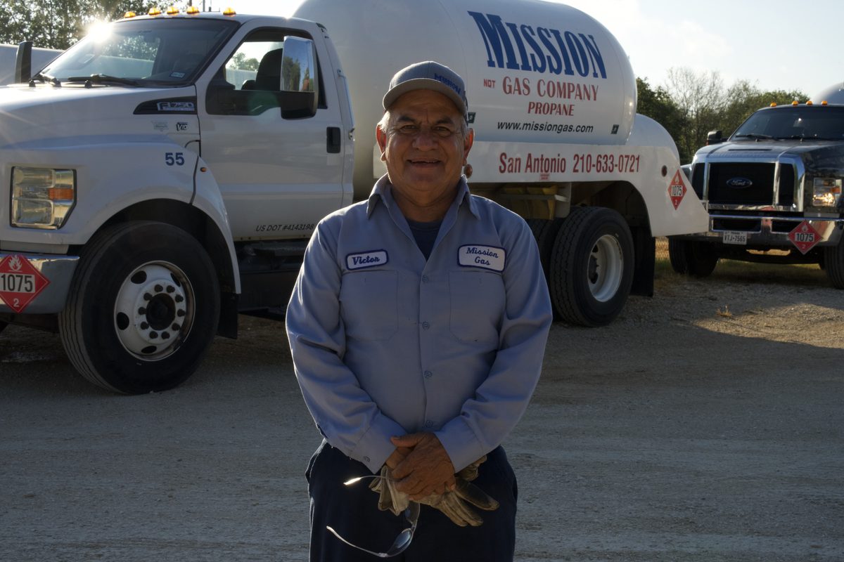 Mission Gas employee standing in front of a propane tanker truck in San Antonio