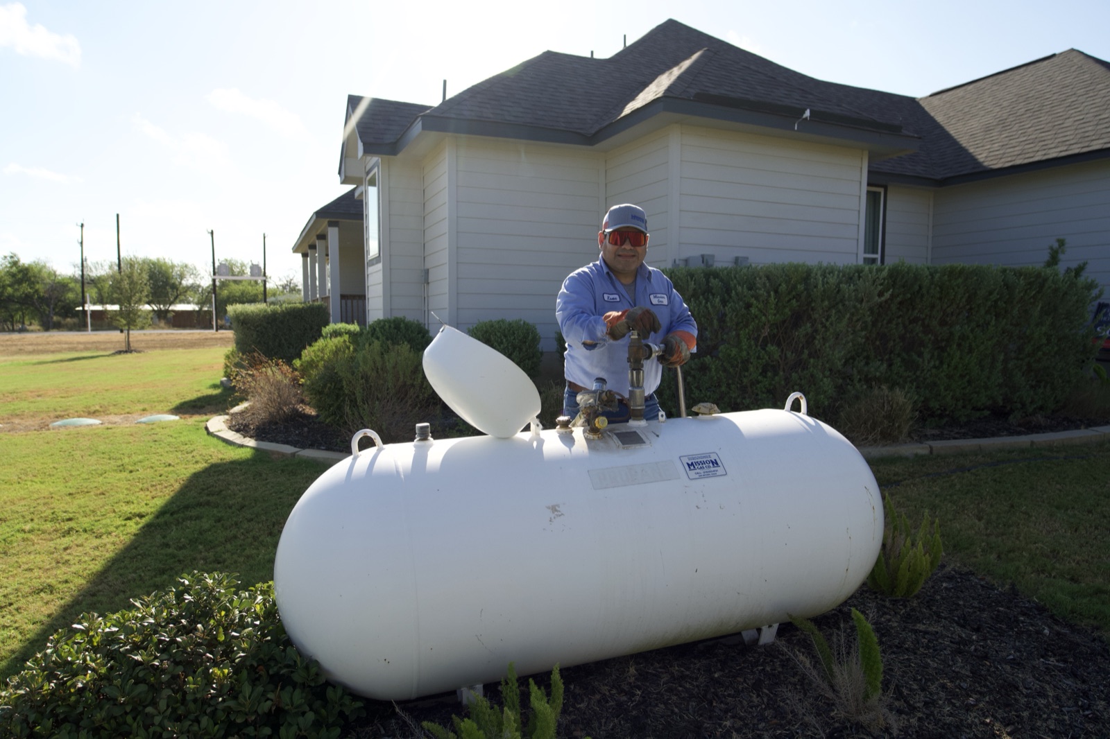 Staples, TX technician installing a propane tank at a residential property