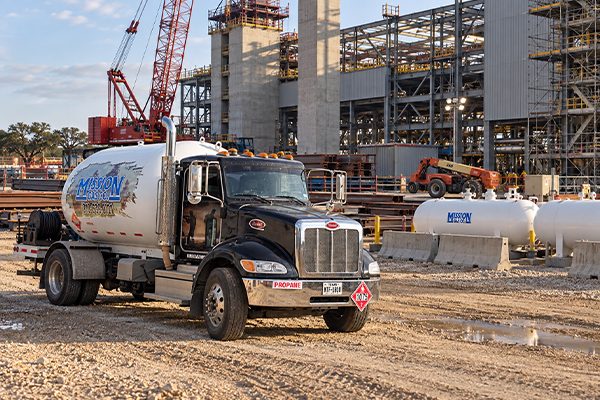 Mission Gas propane delivery truck and storage tanks at a commercial construction site