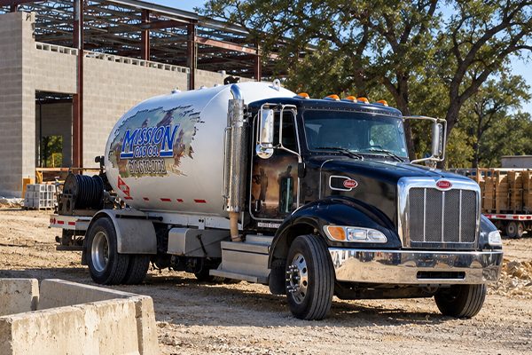 Mission Gas propane delivery truck parked beside a newly built home